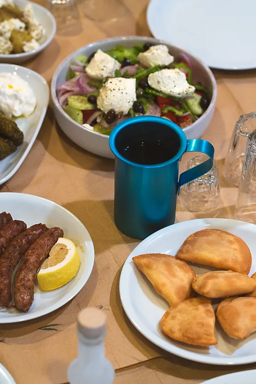 Το τραπέζι με χωριάτικη, λουκάνικα και καλιτσούνια